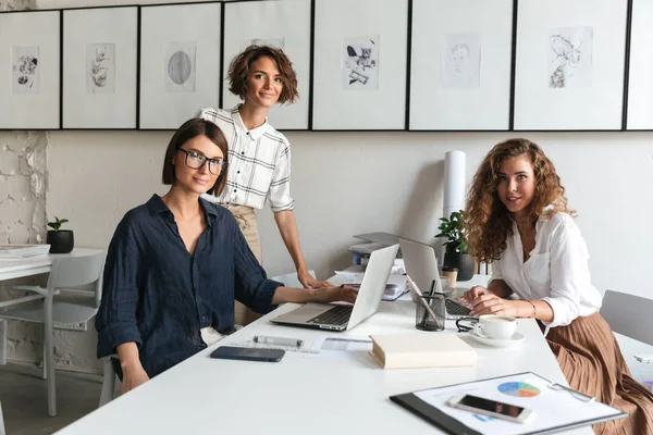 Üç kadın yan görünüm bir şey görüşüyorlar