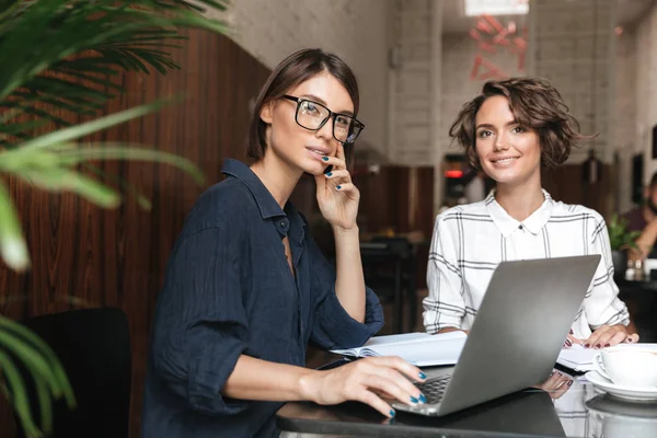 Masaya oturan iki kadın yöneticileri yan görünüm
