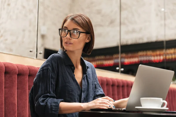 Vista laterale del manager donna in occhiali da vista seduto al tavolo — Foto Stock