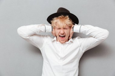 Genç Beyaz adam eliyle kulaklarını kapsayan çığlık