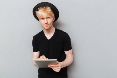 Tablet bilgisayar kullanan beyaz bir adam..