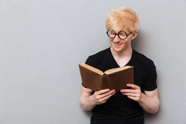 Yakışıklı neşeli beyaz adam kitap okuma.