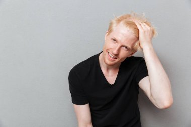 Beyaz adam boşaltmak gülüyor yakınındaki gri duvar üzerinde