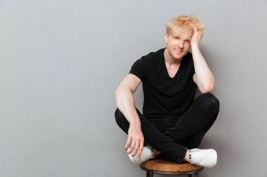 Beyaz adam boşaltmak gülüyor yakınındaki gri duvar üzerinde