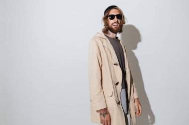 Hipster neşeli adam izole duran güneş gözlüğü takıyor