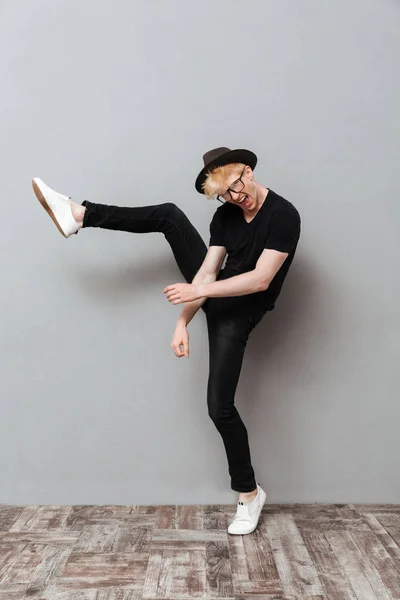 Caucasian man wearing glasses walking over grey wall — Stock Photo, Image