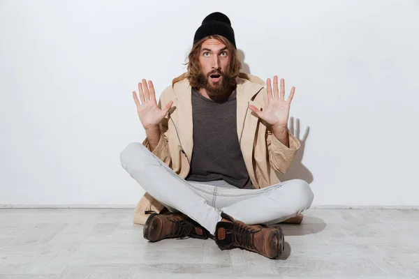 Shocked hipster man looking camera sitting isolated — Stock Photo, Image