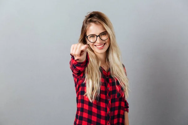 Sorrindo jovem loira mulher apontando para você . — Fotografia de Stock