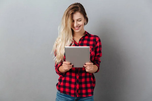 Fröhliche junge blonde Frau im Chat per Tablet-Computer. — Stockfoto