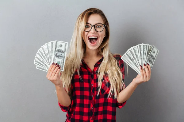 Χαρούμενος νεαρός ξανθιά γυναίκα που κρατά χρήματα. — Φωτογραφία Αρχείου