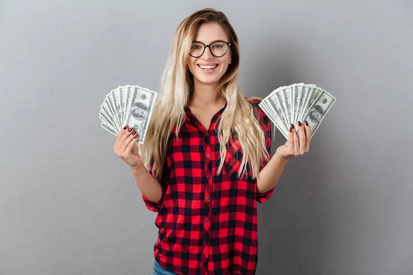 Gelukkig jonge blonde vrouw aanhouden van geld. — Stockfoto
