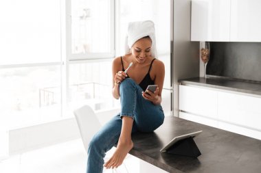 Asyalı kadın kafasını sarılı banyo havlusu ile gülümseyen