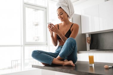 Mutlu genç Asyalı kadın ile onun başının etrafında sarılı banyo havlusu