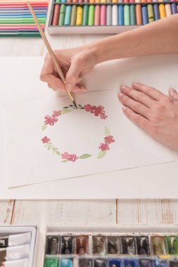 Genç sanatçı suluboya boya ve fırça ile desen çizimi