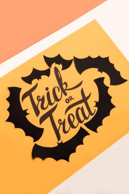 Logo Cadılar Bayramı ve turuncu zemin üzerine boyalı siyah yarasa