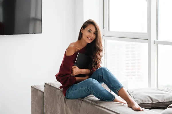 Mujer bonita sonriente en suéter sosteniendo tableta — Foto de Stock