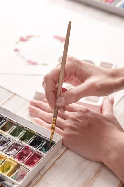 Junge Künstlerin zeichnet Muster mit Aquarellfarbe und Pinsel — Stockfoto