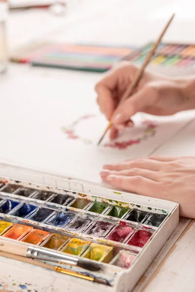 Genç sanatçı suluboya boya ve fırça ile desen çizimi