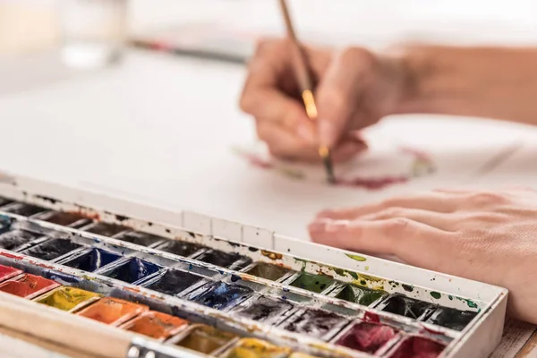 Genç sanatçı suluboya boya ve fırça ile desen çizimi