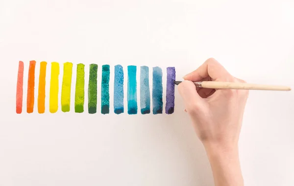 Artista pintura listras coloridas com escova em papel branco — Fotografia de Stock