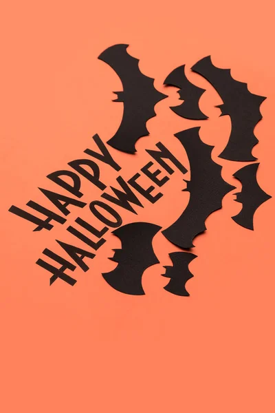 Чёрный логотип Хэллоуина и чёрные летучие мыши на оранжевом фоне — стоковое фото