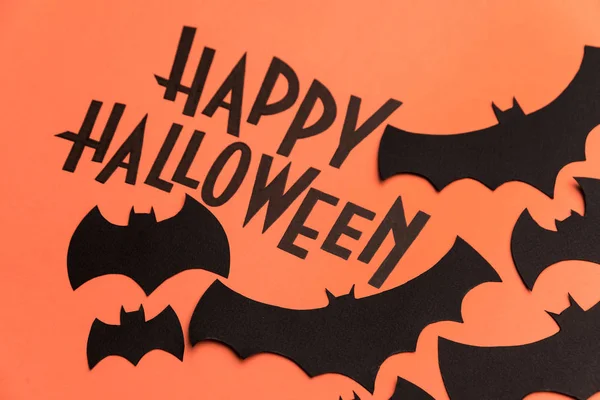 Logo noir d'Halloween et chauves-souris noires peintes sur fond orange — Photo