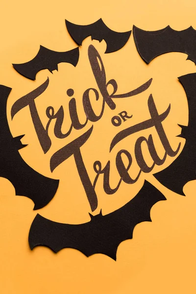 Logo Cadılar Bayramı ve turuncu zemin üzerine boyalı siyah yarasa