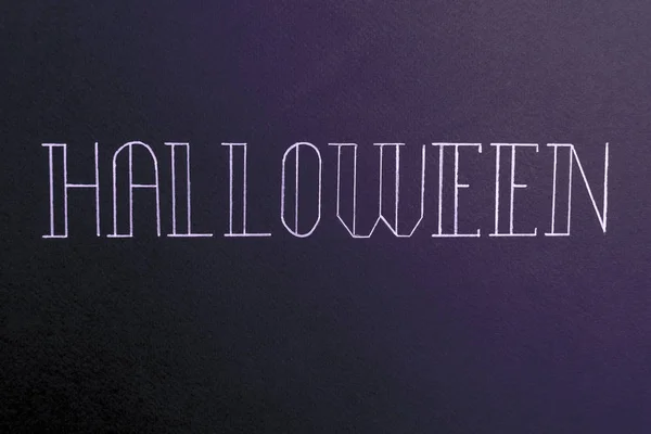 Řez písma text pro halloween logo na černém pozadí v rukou, — Stock fotografie