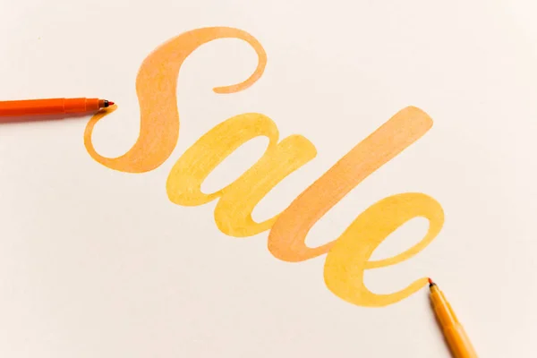 Orange bemalter Schriftzug Verkauf auf weißem Hintergrund — Stockfoto