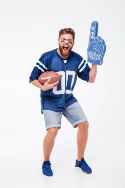 Çığlık atan adam tribünleri dolduran mavi t-shirt ragbi topu tutan.