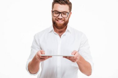 Tablet bilgisayar kullanan neşeli genç sakallı adam.