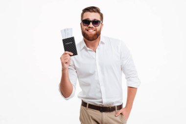 Pasaport ve bilet tutan adam genç sakallı.