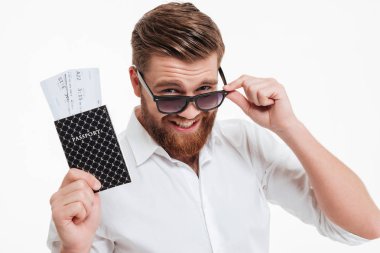 Pasaport ve bilet tutan adam genç sakallı.