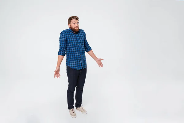 Full length portrait of a confused young bearded man — Stock Photo, Image