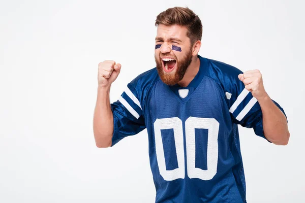 Esperanzado hombre emocionado ventilador en azul camiseta de pie aislado — Foto de Stock