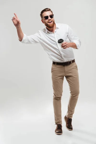 Lächelnder junger bärtiger Mann, der Kaffee trinkt. — Stockfoto