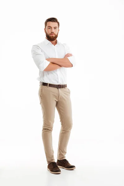 Serious young bearded man standing over white wall — Stock Photo, Image