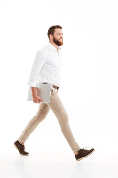 Yakışıklı genç sakallı adam beyaz duvar'ın üstüne yürüyor — Stok fotoğraf