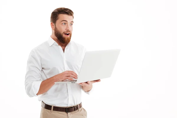 Dizüstü bilgisayar kullanan yakışıklı genç sakallı adam. — Stok fotoğraf