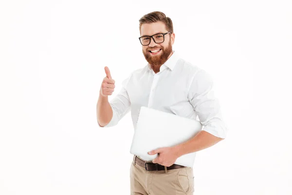Handsome young bearded man holding laptop showing thumbs up. — Stock Photo, Image