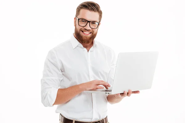 Gelukkig jonge bebaarde man met laptop. — Stockfoto