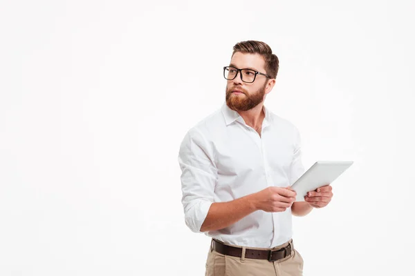 Hombre barbudo joven serio usando tableta . — Foto de Stock