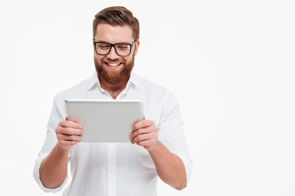 Veselý mladý vousatý muž používající počítač tabletu. — Stock fotografie