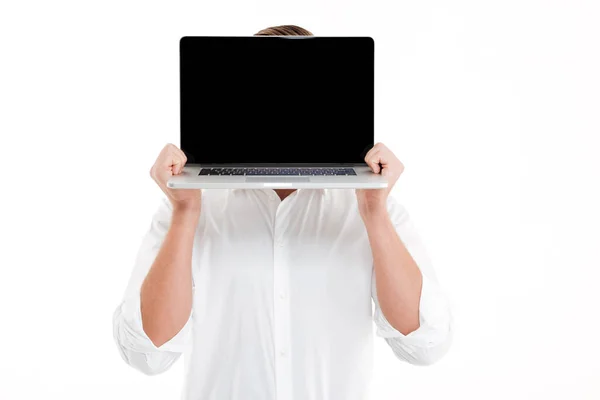 Man standing over white wall showing display of laptop. Stock Image