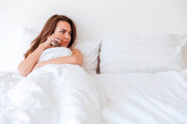 Boş yatakta yatan ve birilerini arayıp kızgın kadın