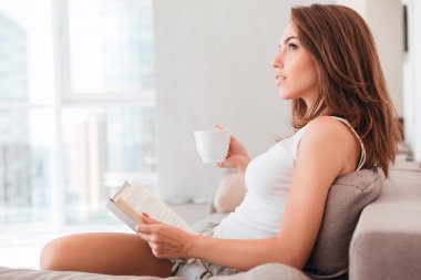 Dalgın bir kız bir kitap okuma yan görünüm