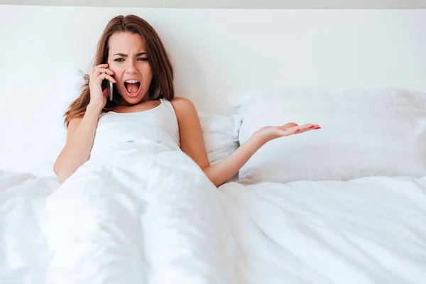 Pazzo pazzo donna sdraiata nel letto vuoto e urlando — Foto Stock