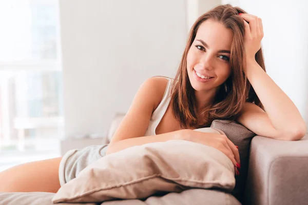Çok gülümseyen kadın evde kanepede yalan — Stok fotoğraf
