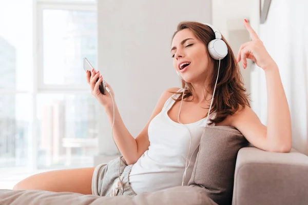 Joven mujer bonita en auriculares escuchando música — Foto de Stock