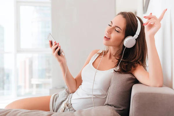 Joven alegre en auriculares escuchando música — Foto de Stock